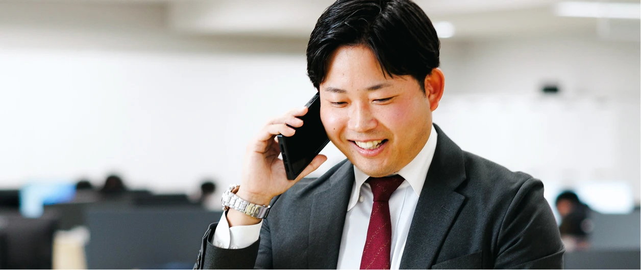 オフィスで顧客と電話をする営業職の写真