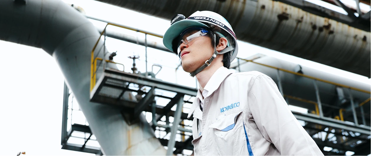 工場の敷地内で歩く施工管理職の写真