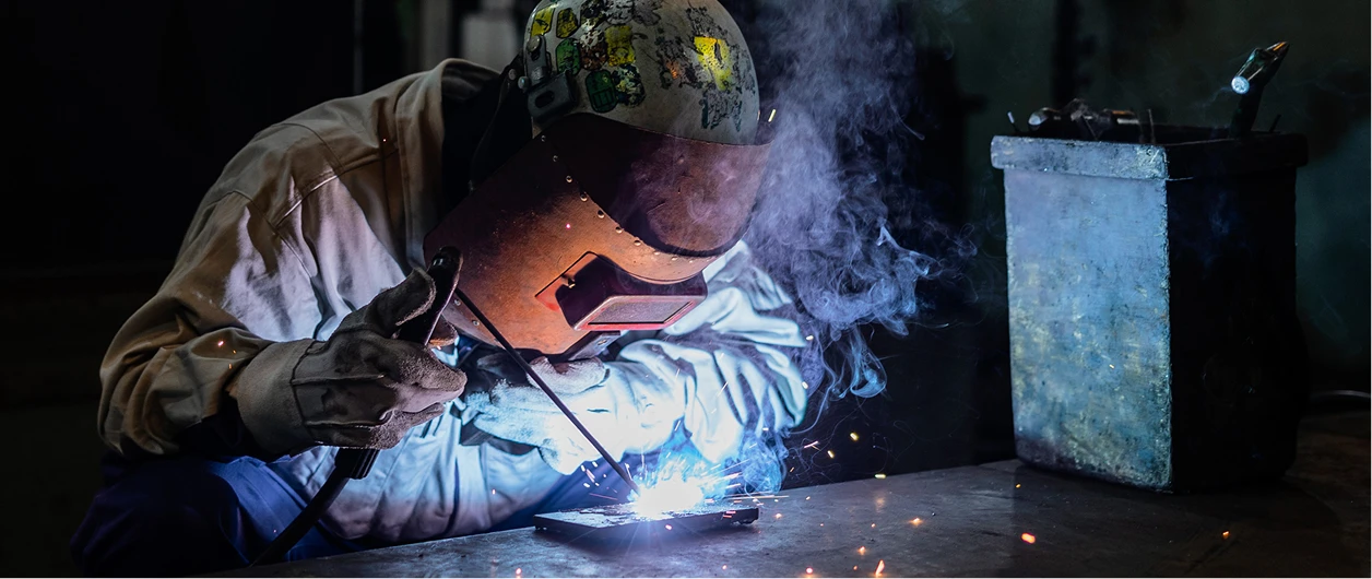 工場内で鉄骨を溶接する整備職の写真