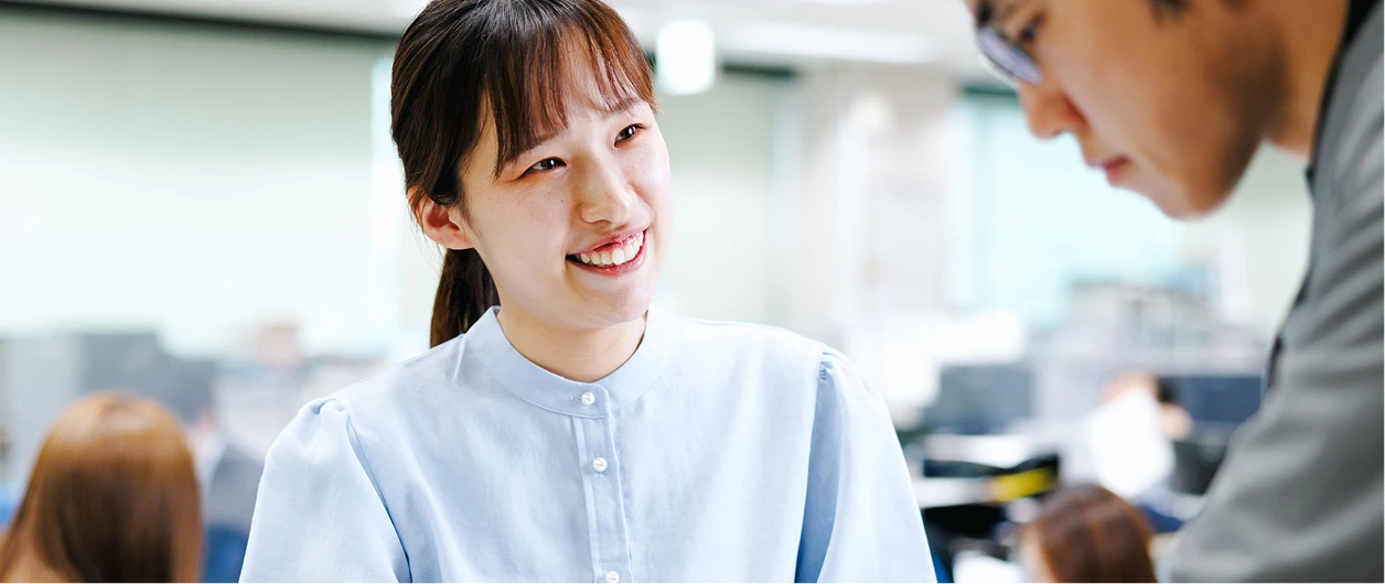 オフィスで社員と打ち合わせをする事業支援職の写真